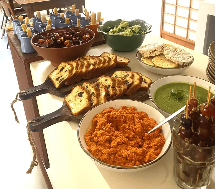 Houten planken met geroosterd brood en schalen met dips en hapjes op een buffettafel